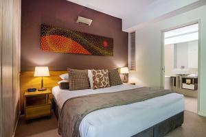 a bedroom with a large bed and a bathroom at Perfect luxury for 2, Noosa Heads in Noosa Heads