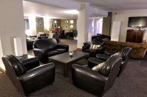 a lobby with leather chairs and a living room at Hotel Kandahar in Pas de la Casa