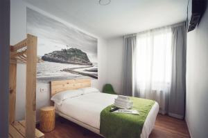 Schlafzimmer mit einem Bett mit Wandgemälde in der Unterkunft Casual Serantes in Bilbao
