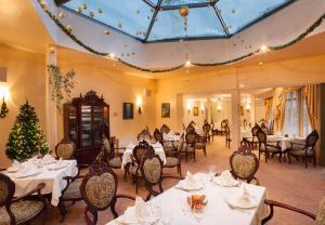 a dining room with tables and chairs and a christmas tree at Bistra & Galina Hotel in Ruse