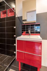 a red sink in a bathroom with black tiles at Palo Alto Cottage by Stanford & Tech Companies in Palo Alto
