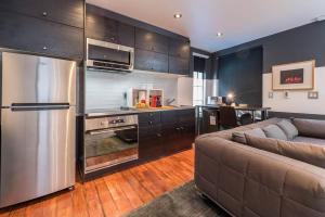 a kitchen with a stainless steel refrigerator and a couch at Palo Alto Cottage by Stanford & Tech Companies in Palo Alto