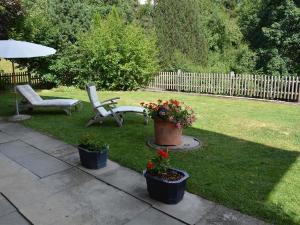 een tuin met twee stoelen en een parasol en bloemen bij Apartment Sambi by Interhome in Gstaad