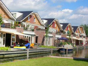 a row of houses on a river with boats in it at Apartment Oostergeest by Interhome in Uitgeest