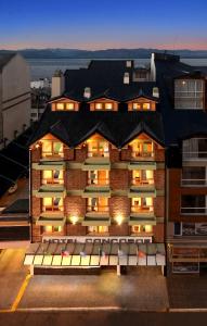 a large brick building with lights on at Hotel Concorde in San Carlos de Bariloche