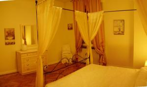 ベルガモにあるLa Castellanaのベッドルーム(天蓋付きベッド1台、ドレッサー付)