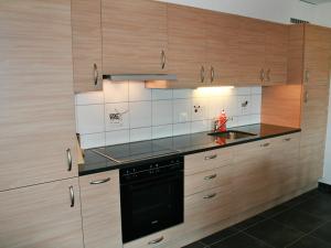 a kitchen with wooden cabinets and a black appliance at Apartment Andromède 4 pièces 11 by Interhome in Moleson