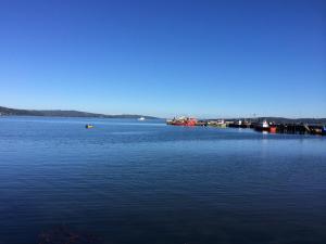 a large body of blue water with a dock at Cabañas Don Hugo in Ancud +6 photos