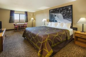 a hotel room with a large bed and a table at Super 8 by Wyndham Remington in Remington