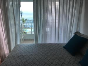 a bedroom with a bed with a view of the ocean at Apartamento Juan Dolio in Juan Dolio