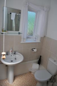 a bathroom with a sink and a toilet and a window at The Willows in Whitby