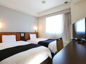 東京にあるアパホテル〈三田駅前〉のベッド2台、薄型テレビが備わるホテルルームです。