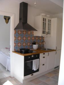 cocina con fogones y fregadero en Casa Kruttornet & Villa Fiskarporten en Visby