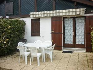 a white table and chairs in front of a building at Holiday Home Paradise Océan-5 by Interhome in Capbreton