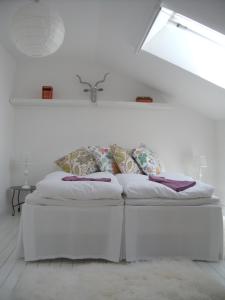 una cama blanca con almohadas en una habitación en Casa Kruttornet & Villa Fiskarporten, en Visby