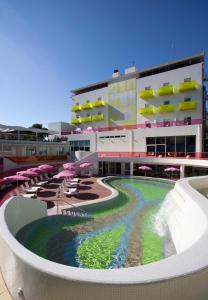 a large building with a swimming pool with umbrellas at Semiramis in Athens