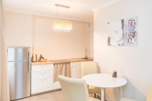 a kitchen with a table and a refrigerator at Cozy apartment in Cesis in Cēsis