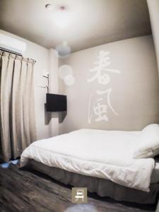 a bedroom with a bed with a sign on the wall at Feb hostel in Tainan +12 photos