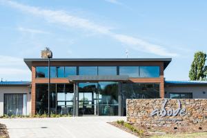 a building with glass doors and a stone wall at Abode Murrumbateman in Murrumbateman