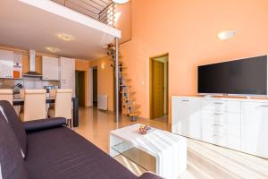 a living room with a couch and a flat screen tv at Luxury apartments Kostrena with pool in Kostrena