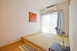 a bedroom with a bed and a window with purple flowers at Lucy's House横浜中華街 House1 in Yokohama