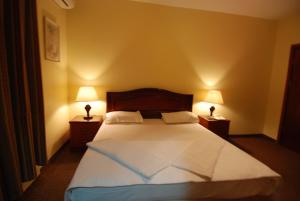 a bedroom with a large bed with two lamps at Al Rashid Hotel in Wadi Musa +37 photos
