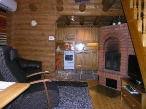 a living room with a fireplace in a log cabin at Holiday Home Mökinniemi by Interhome in Soiniemi