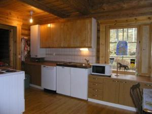 cocina con electrodomésticos blancos y techo de madera en Holiday Home Uutela by Interhome, en Hauhola