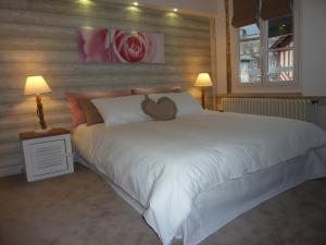 a bed room with a white bedspread and pillows at Hotel le P'tit Beaumont in Beaumont-en-Auge