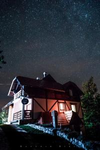 une maison la nuit avec les étoiles dans le ciel dans l'établissement Apartments Andrić, à Kaluđerske Bare