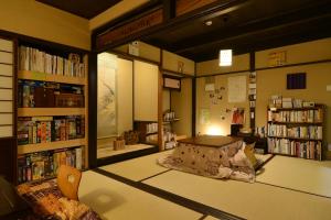 una habitación con estanterías y una cama en una biblioteca en Guest House Bokuyado en Kyoto