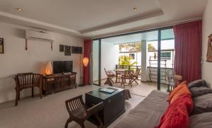 a living room with a couch and a television at Sai Naam Lanta - Apartments & Townhouses in Ko Lanta