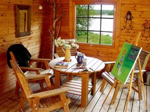 ein Holzzimmer mit einem Tisch und Stühlen in einer Hütte in der Unterkunft Holiday Home Hämeenhelmi by Interhome in Pätiälä