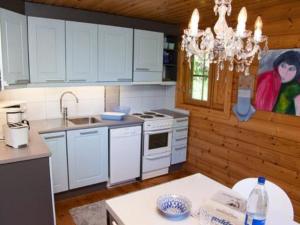 eine Küche mit weißen Schränken und einem Kronleuchter in der Unterkunft Holiday Home Hämeenhelmi by Interhome in Pätiälä