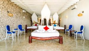 Habitación con 4 camas y sillas azules. en Amatoa Resort, en Bira