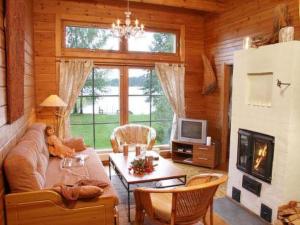 a living room with a couch and a table at Holiday Home Alahuone by Interhome in Pätiälä