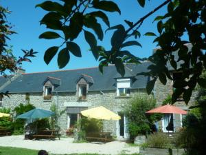 a building with tables and umbrellas in front of it at Gite Les Oyats in Cancale