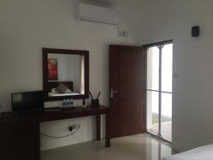 a bedroom with a desk and a mirror and a door at Villa A50 in Negombo