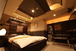 a bedroom with a bed and a chair in it at Hotel La Siena (Adult Only) in Higashi-osaka