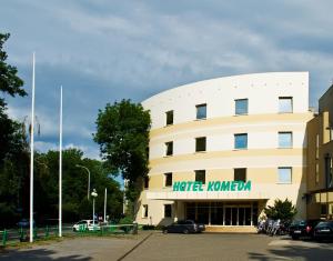 a white building with a hotel korean sign on it at Hotel Komeda in Ostrów Wielkopolski