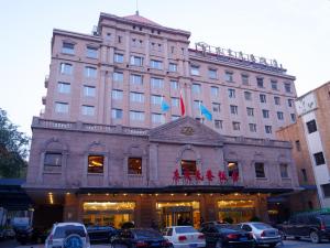 duży budynek z samochodami zaparkowanymi przed nim w obiekcie Beijing Dongjiaominxiang Hotel w Pekinie