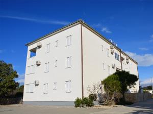 a white building with windows on the side of it at Babe beach Apartment in Novalja