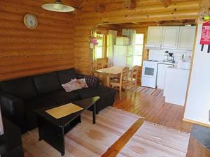 a living room with a couch and a kitchen at Holiday Home Lepolahti by Interhome in Virrat