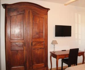 a large wooden door in a room with a desk at Hôtel La Tour Perrier in Eyrans-de Soudiac