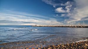 a beach with the ocean and a city in the background at Hôtel Les 3 Terrasses in Sari Solenzara