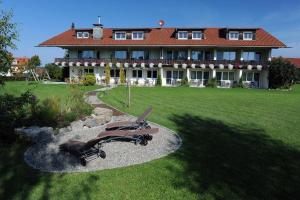 a large house with a large yard with chairs in front of it at Hotel Bergblick in Scheidegg