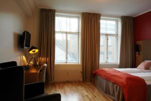 Habitación de hotel con cama y ventana en City Living Schøller Hotel, en Trondheim
