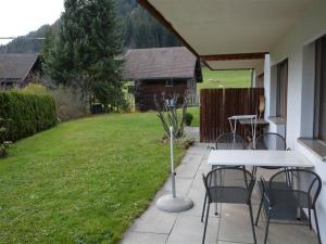 a patio with a table and chairs in a yard at Apartment Simmental by Interhome in Zweisimmen
