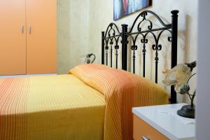 a bedroom with a bed with a yellow blanket at Baccaversa camere in Marina di Mancaversa
