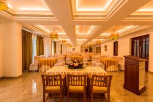 a banquet hall with tables and chairs and a podium at Regenta Central Herald Mysore in Mysore